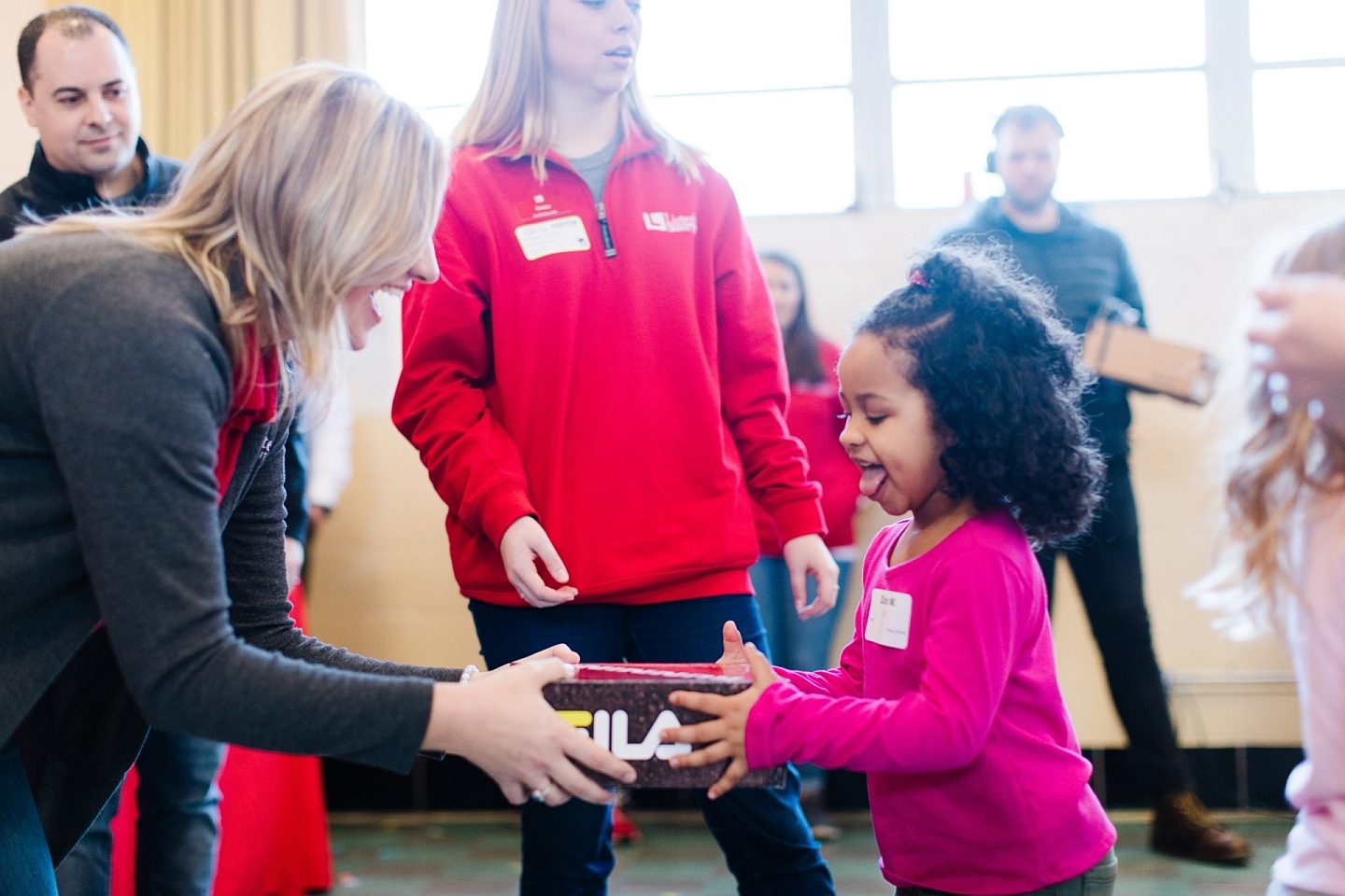 Listerhill Employee Giving Little Girl A Pair of Shoes (Kicks for Kids)